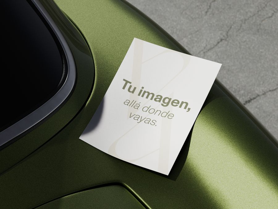 Tarjeta con el mensaje “Tu imagen, allá donde vayas” sobre la carrocería verde metálica de un vehículo